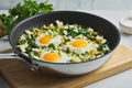 Green shakshouka. Fried in pan. Eggs, parsley, celery, spinach, sheep cheese, pepper