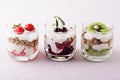 Vegetarian desserts with cottage cheese, granola, strawberry, cherry, kiwi on pink background