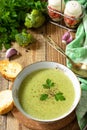 Delicious broccoli cream soup served with garlic croutons on a rustic table. Copy space