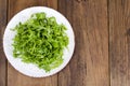 Vegetarian dish, plate with green arugula on wooden table Royalty Free Stock Photo