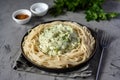 Vegetarian dish: spaghetti with cheese sauce, broccoli and vegetables. Delicious pasta with parmesan on a gray