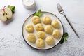 Vegetarian gluten-free steamed lazy dumplings with apple filling on a white plate, decorated with mint surrounded by half an apple Royalty Free Stock Photo