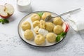 Vegetarian gluten-free steamed lazy dumplings with apple filling on white plate, decorated with mint surrounded by half Royalty Free Stock Photo