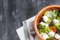 Vegetarian Greek salad with feta cheese, arugula, olives and cherry tomatoes and italian herbs in clay bowl Royalty Free Stock Photo