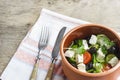 Vegetarian Greek salad with feta cheese, arugula, olives and cherry tomatoes and italian herbs in clay bowl Royalty Free Stock Photo