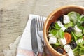 Vegetarian Greek salad with feta cheese, arugula, olives and cherry tomatoes and italian herbs in clay bowl Royalty Free Stock Photo