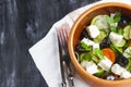 Vegetarian Greek salad with feta cheese, arugula, olives and cherry tomatoes and italian herbs in clay bowl Royalty Free Stock Photo