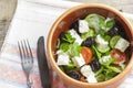 Vegetarian Greek salad with feta cheese, arugula, olives and cherry tomatoes and italian herbs in clay bowl Royalty Free Stock Photo