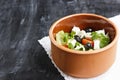 Vegetarian Greek salad with feta cheese, arugula, olives and cherry tomatoes and italian herbs in clay bowl Royalty Free Stock Photo