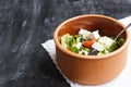 Vegetarian Greek salad with feta cheese, arugula, olives and cherry tomatoes and italian herbs in clay bowl Royalty Free Stock Photo