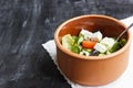 Vegetarian Greek salad with feta cheese, arugula, olives and cherry tomatoes and italian herbs in clay bowl Royalty Free Stock Photo