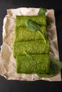 Vegetarian green pancakes. Spinach pancakes rolled up on a baking paper. Spinach vegetarian recipes