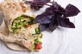 Vegetarian halfs of shawarma sandwich roll with purple basil leaves. served in provence style. Healthy fast food. close up
