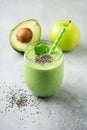 Vegetarian healthy green smoothie from avocado, spinach leaves, apple and chia seeds on gray concrete background. Selective focus Royalty Free Stock Photo