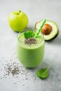 Vegetarian healthy green smoothie from avocado, spinach leaves, apple and chia seeds on gray concrete background. Selective focus Royalty Free Stock Photo