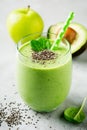 Vegetarian healthy green smoothie from avocado, spinach leaves, apple and chia seeds on gray concrete background. Selective focus Royalty Free Stock Photo
