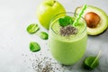 Vegetarian healthy green smoothie from avocado, spinach leaves, apple and chia seeds on gray concrete background. Selective focus Royalty Free Stock Photo