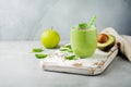 Vegetarian healthy green smoothie from avocado, spinach leaves, apple and chia seeds on gray concrete background. Selective focus Royalty Free Stock Photo
