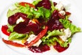 Vegetarian kitchen & healthy food concept. Fresh vegetable salad of sun-fried tomatoes, lettuce, beet and caprine cheese. Close up