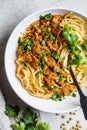 Vegetarian lentils bolognese pasta with parsley in white dish, top view. Healthy vegan food concept