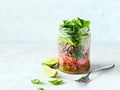 Vegetarian lunch salad in a jar with quinoa, tomatoes, spinach and lettuce