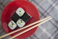 Vegetarian maki on red plate with soy sauce