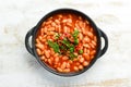 Vegetarian menu. Stewed beans in tomato sauce with parsley and chili. In a black bowl. Top view. Royalty Free Stock Photo