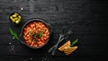 Vegetarian menu. Stewed beans in tomato sauce with parsley and chili. In a black bowl. Top view. Royalty Free Stock Photo