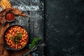 Vegetarian menu. Stewed beans in tomato sauce with parsley and chili. In a black bowl. Top view. Royalty Free Stock Photo