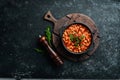 Vegetarian menu. Stewed beans in tomato sauce with parsley and chili. In a black bowl. Top view. Royalty Free Stock Photo