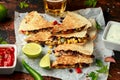 Vegetarian mexican black beans tomato cheese and corn quesadilla served with cold beer salsa and yogurt dip sause on dark wooden Royalty Free Stock Photo