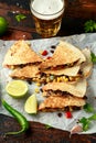 Vegetarian mexican black beans tomato cheese and corn quesadilla served with cold beer salsa and yogurt dip sause on dark wooden Royalty Free Stock Photo