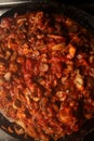 Vegetarian mushrooms chickpea stew in a iron pan on a dark background, top view