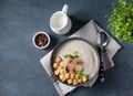 Vegetarian mushrooms cream soup with croutons and herbal in gray bowl on dark background. Top view and copy space