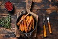 Vegetarian Oven baked sweet potato fries. Dark wooden background. Top view