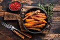 Vegetarian Oven baked sweet potato fries. Dark wooden background. Top view