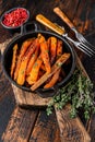 Vegetarian Oven baked sweet potato fries. Dark wooden background. Top view