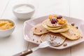 Vegetarian pancakes with honey, raspberries and physalis, sprinkled with powdered sugar with sour cream and jam on white Royalty Free Stock Photo