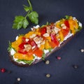 Baked eggplants stuffed with vegetable, walnut and cream cheese on a black slate background, close up