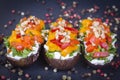 Baked eggplants stuffed with vegetable, walnut and cream cheese on a black slate background, close up