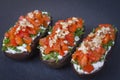 Baked eggplants stuffed with vegetable, walnut and cheese on a black slate background, close up