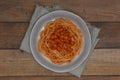 Vegetarian pasta stewed beans in tomato sauce on wood background.