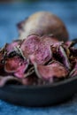 Vegetarian pile of healthy beet chips Purple Baked Beet Chips Vegan snacks, vegetable chips in canvas bag and ceramic bowl, rustic