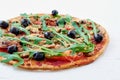 Vegetarian pizza with mushrooms, tomatoes, black olives, rucola on the white table isolated Royalty Free Stock Photo