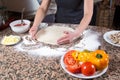 Vegetarian Pizza Preparation - Baker Kneading Dough Surrounded By Ingredients On Marble Table