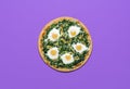 Vegetarian pizza with spinach and eggs isolated on purple color. Pizza, flat lay