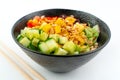 Vegetarian poke bowl in design black bowl with chopsticks below, isolated on white background. Green cucumber, red pepper, peanuts Royalty Free Stock Photo