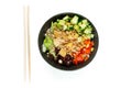 Vegetarian poke bowl in design black bowl with chopsticks below, isolated on white background. Green cucumber, red pepper, peanuts