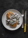 Vegetarian potato patties with creamy mushroom sauce on a dark background, top view Royalty Free Stock Photo