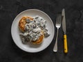 Vegetarian potato patties with creamy mushroom sauce on a dark background, top view Royalty Free Stock Photo